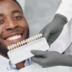 man smiling while female dentist keeping range fillings